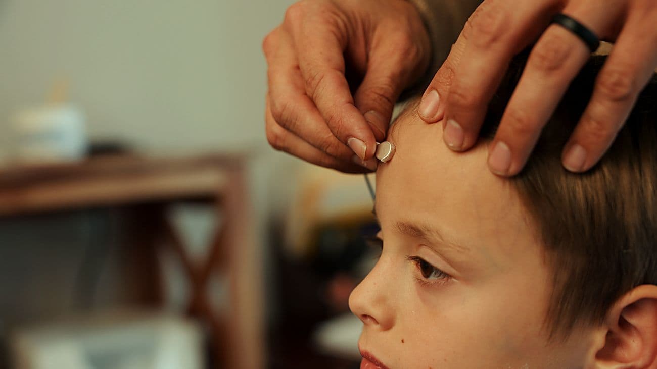 A child with a small LENS sensor gently placed