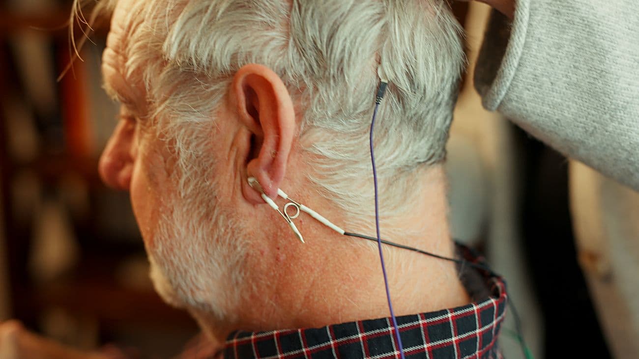 A senior client with an ear-clip sensor during a session